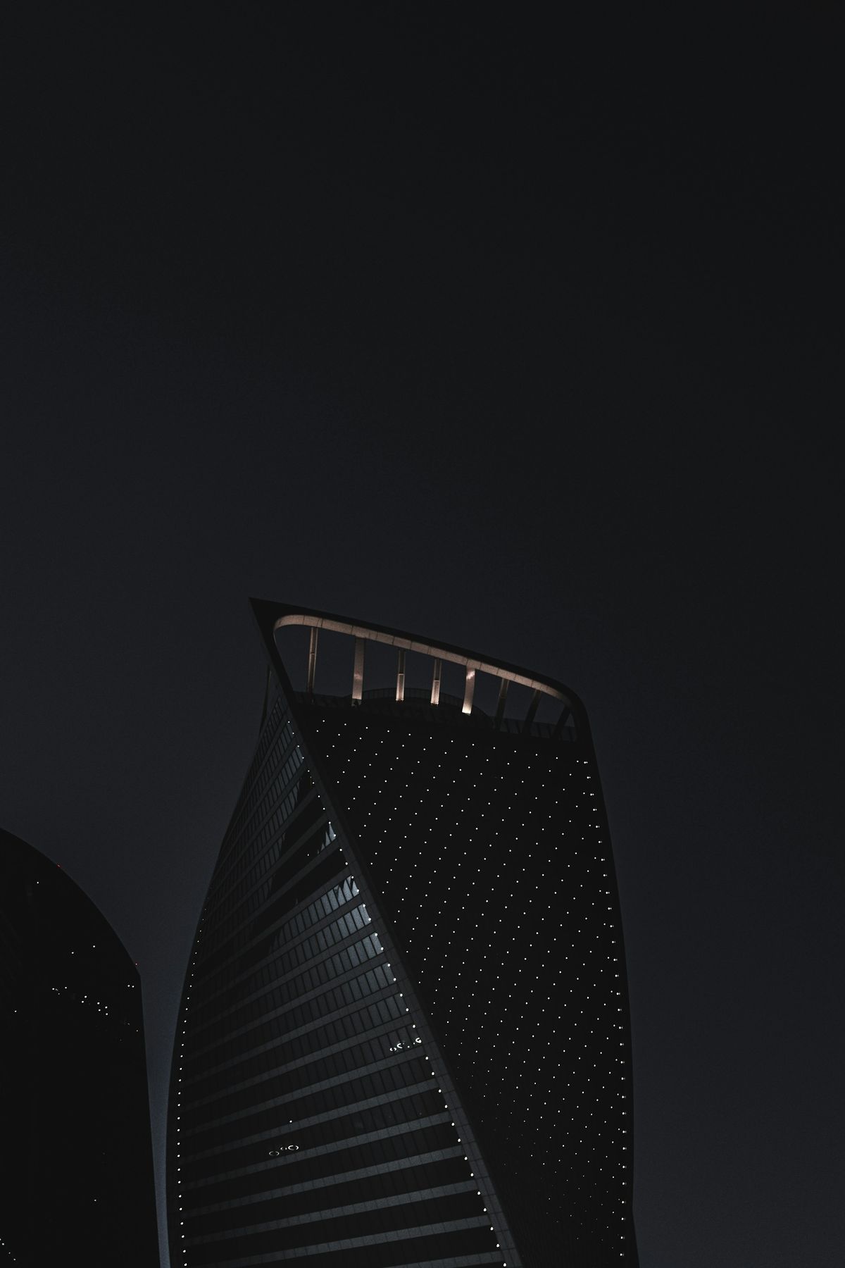 A dark office tower with lit windows at night